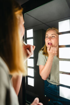 Female traveler getting ready in hotel room at mirror