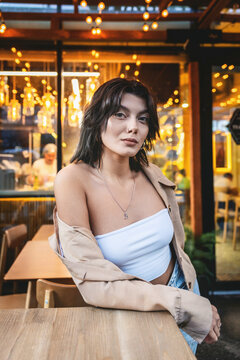 Portrait of a young woman in a cafe with warm bokeh lighting