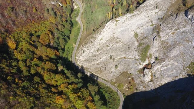  Aerial top down view of deep canyon, gorge road in autumn forest 