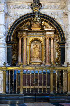 Ornate gilded side chapel retable with saint sculpture and bronze railing inside the Cathedral of San Salvador, La Seo in Zaragoza, Spain.