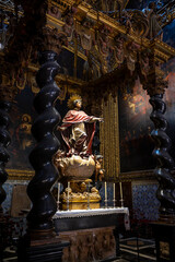 Vertical view of the Chapel of Saint Peter Arbués featuring a baroque ciborium with Solomonic columns, statue, and gothic ribbed vault in the Cathedral of San Salvador, La Seo in Zaragoza, Spain. © javier