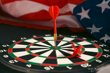 Fototapeta premium Darts and dartboard on the background of the American flag.
