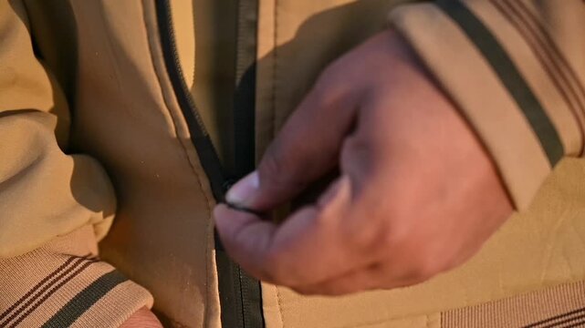 Close Up of Person Zipping Up Winter Jacket Outdoors, Hand Fastening Coat Zipper in Cold Weather, Fashion and Lifestyle Concept, 4K Footage