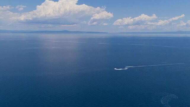 Jet ski making circular wake pattern on calm blue sea