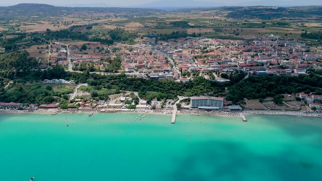 Aerial view of coastal town with turquoise water and beach pier