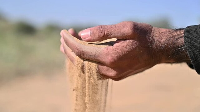 Close Up of Human Hands Holding and Letting Fine Sand Fall Through Fingers in Nature, Symbolizing Time, Life, Change and Impermanence 4K Footage