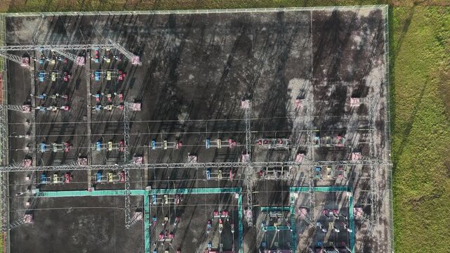 Aerial view of an electrical substation showing transformers and high voltage power lines.