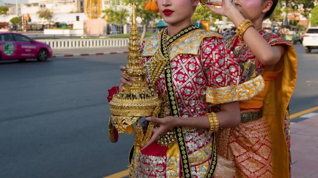 Traditional Thai Dancers in Ornate Costumes Preparing on a City Street