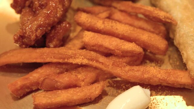 Close Up of Korean Fried Chicken and French Fries on Brass Plate