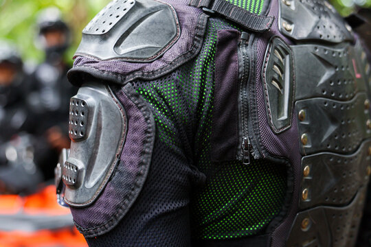 Armored motorcycle jacket with molded shoulder and back protection, textured textile and zipper detail conveying rugged safety and readiness for riding