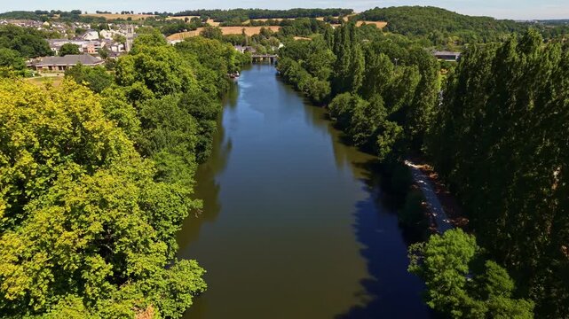 Drone flies above the Mayenne River with Parc des Ondines and Saint Pierre Church in Chang&eacute;, France.