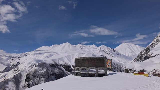 Drone footage of the Georgia-Russia Friendship Monument in Gudauri, revealing colorful interior murals against a snowy mountain backdrop.