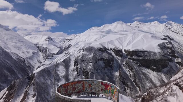 Unique snowy Caucasian mountain scenery revealing the Georgia-Russia Friendship Monument in Gudauri surrounded by dramatic winter terrain.
