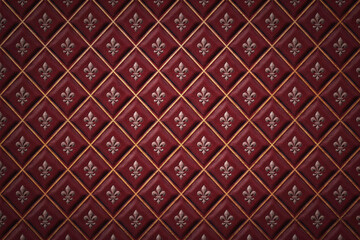 Obraz premium Deep burgundy red leather upholstery with a diamond tufted pattern and metallic silver fleur de lis symbols centered in each quilted section