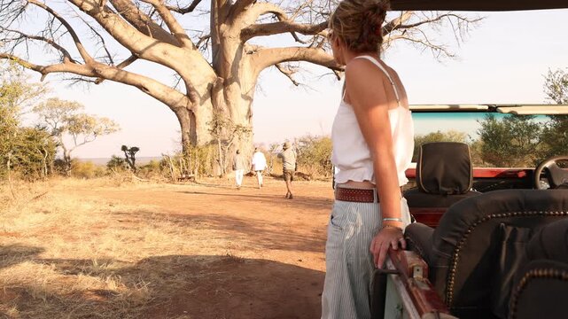 portrait of young woman and vintage safari vehicle, Zambezi National Park, Zimbabwe, Africa 