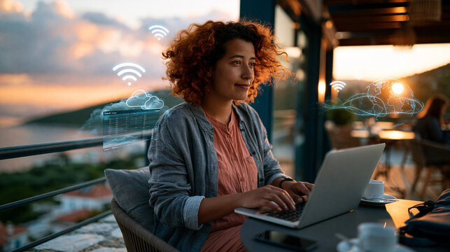 Digital nomad freelancer working on a laptop for remote work on a scenic terrace or cafe abroad, with travel data, WiFi symbols and cloud workflow graphics for global productivity