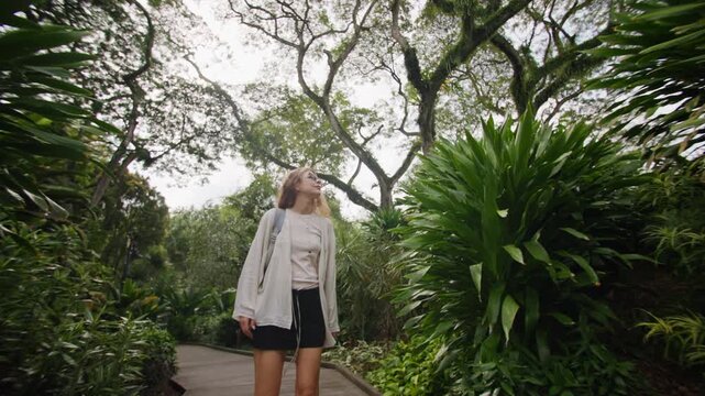 Beautiful tropical landscapes in Singapore Botanic Gardens with a traveler discovering exotic plants and natural scenery in the heart of Asia