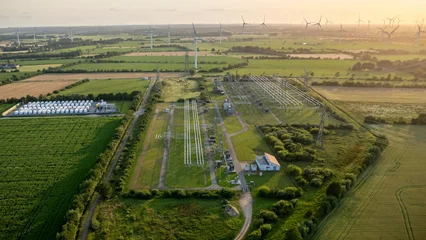 Aerial view of electrical substation, battery energy storage system and wind farm at sunset. Renewable energy infrastructure for grid stability, electricity transmission, and energy transition. © snapshotfreddy
