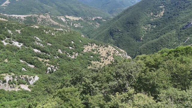 Montagne ricoperte di vegetazione verde con pendii ripidi, vallate naturali e affioramenti rocciosi, in un paesaggio ampio e incontaminato che si estende verso crinali sovrapposti