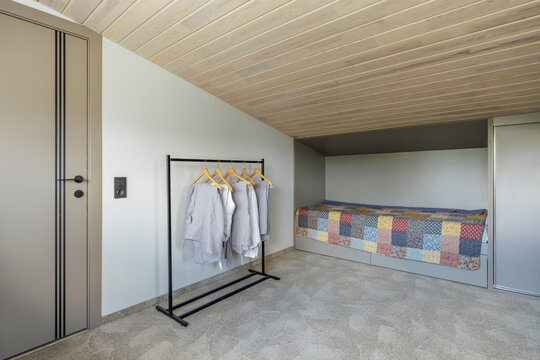 Bedroom Interior with Single Bed, Clothing Rack, and Wardrobe
