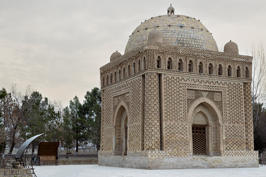 Ismail Samani Mausoleum in Bukhara with intricate terracotta brickwork and dome on a winter day. Historic Uzbekistan landmark ideal for travel publications and cultural heritage projects.