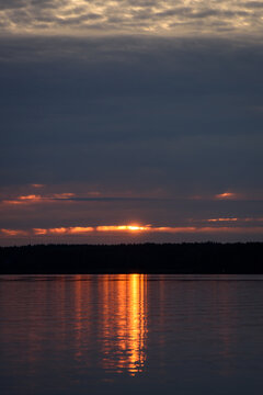 Dramatic Sunrise over Calm Lake with Golden Water Reflection