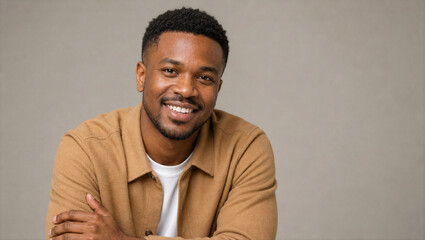 Fototapeta premium Smiling Young Black Man Portrait Against Gray Studio Background With Copy Space