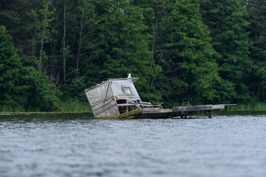 Old Abandoned Wooden Fishing Pier Sinking in Lake Water
