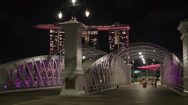 Illuminated Anderson Bridge in Singapore near Marina Bay surrounded by modern skyscrapers creating a stunning night cityscape for travel and tourism in Asia