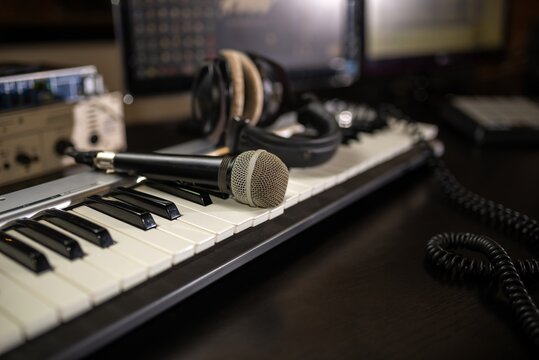 Condenser microphone and keyboard in dimly lit home studio