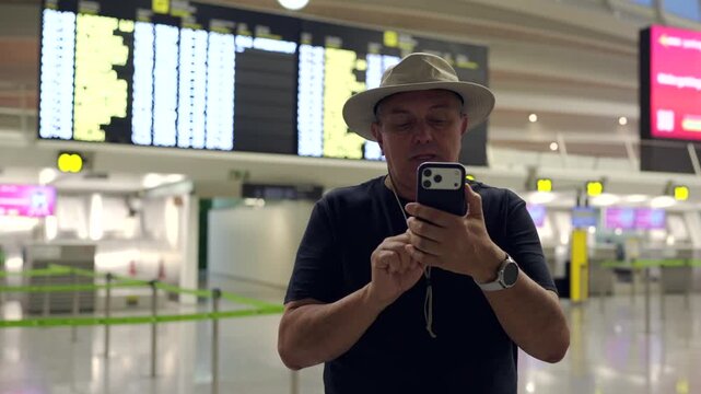 Tourist taking a selfie video at airport departure board