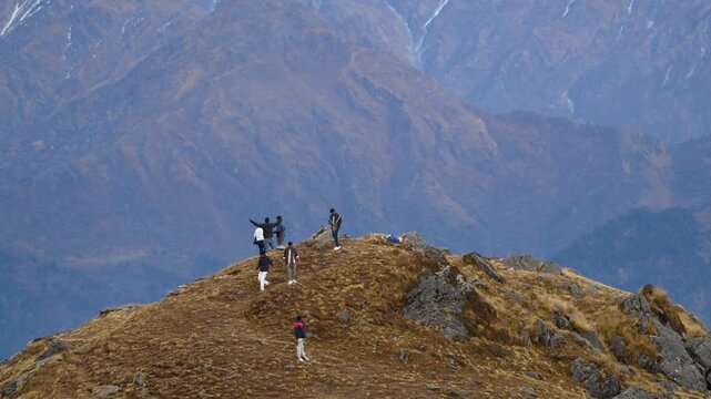 Group Of Trekkers Celebrating On Mountain Ridge Against Massive Himalayan Backdrop