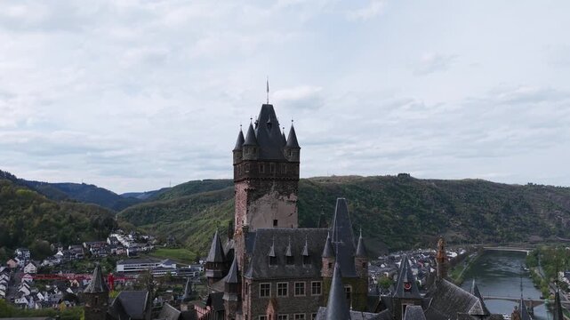 Panoramic aerial perspective of the historic Reichsburg Cochem Castle, charming town, and scenic Moselle River valley in Germany.