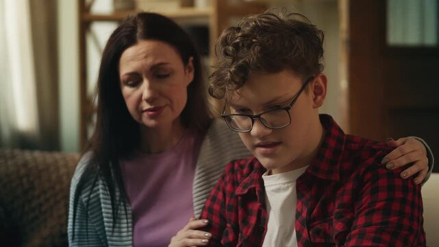 Mother hugging and comforting her upset teenage son, strong parental support