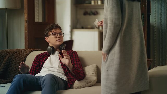 Angry mother reprimanding her teen son for smoking marijuana, showing proof