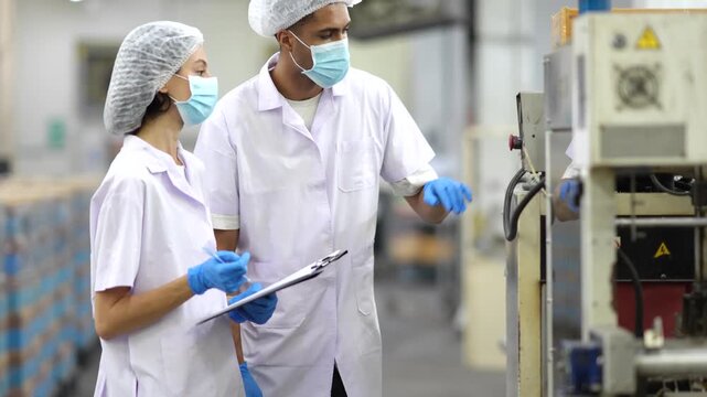 Quality control inspectors checking can packaging machine in food factory. Quality inspection, food safety, packaging line, manufacturing, production process, quality assurance, factory operations.