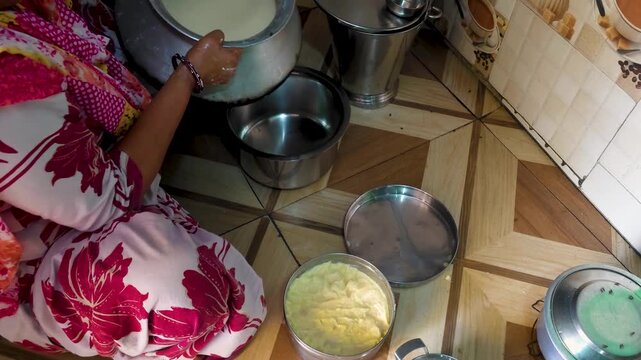 Woman kneading traditional dough in home kitchen a person wearing a patterned garment is shown 