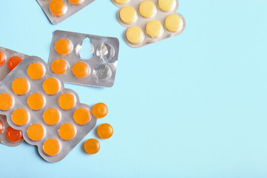 Blisters with cough drops on blue background