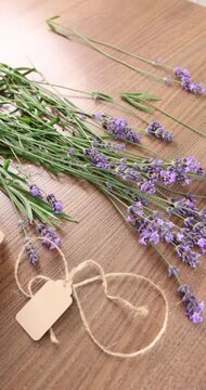 Fresh lavender bouquet kraft tag background video. Purple flower stems with blank craft label and jute twine on wooden table. Creative process or handmade product packing concept for small business.