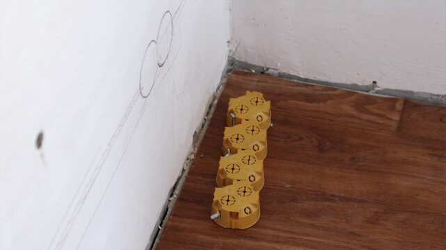 Socket layout marked on wall with yellow junction box on floor