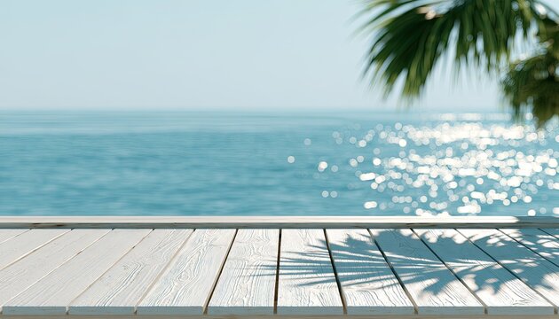 White wooden deck with sparkling ocean and palm leaf shadows