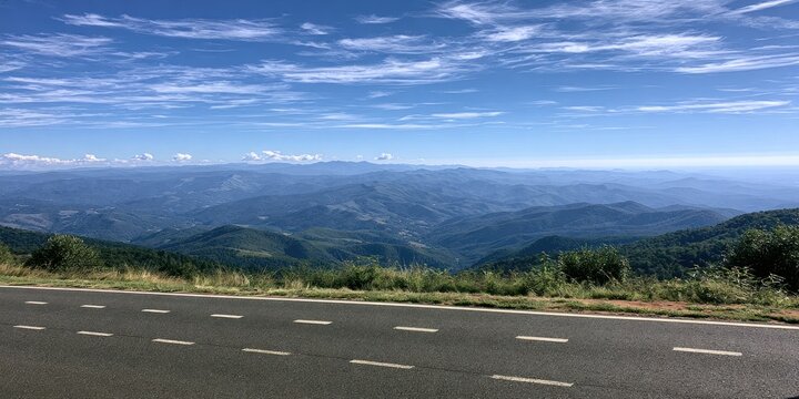 Scenic mountain vista with a road in the foreground under a blue sky