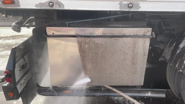 Dirty truck storage compartment before professional washing, showing stained metal surfaces with accumulated road grime, prepared for industrial cleaning, maintenance and fleet service work.