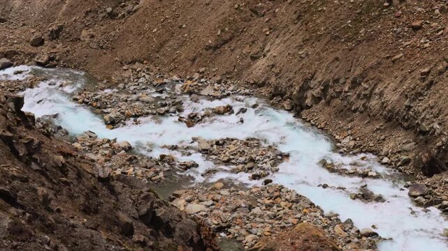 4K Closeup shot of a river stream flowing in between the mountain valley as seen during the Ghepan Ghat Lake trek near Sissu village in Lahaul and Spiti district, Himachal Pradesh, India.