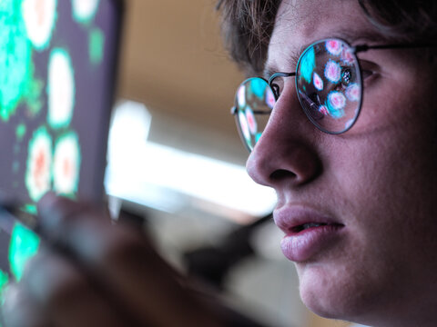 Male expert examining Coronavirus cells on computer monitor in laboratory
