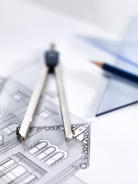 Close-up of drawing equipment on architectural blueprint in office