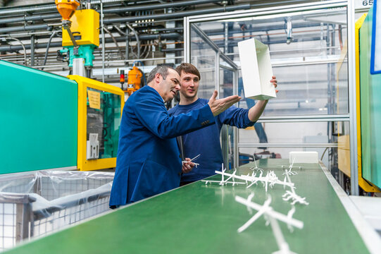 Manager and worker doing quality assessment in plastics factory