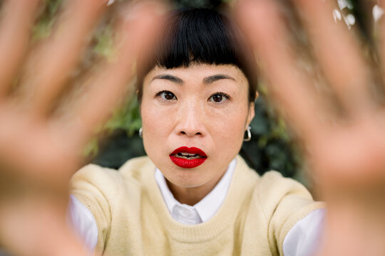 Portrait of smiling woman with red lipstick looking at camera outdoors