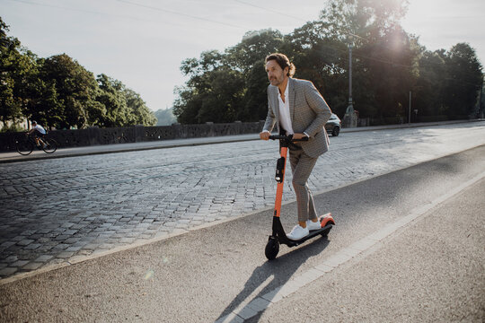 Businessman with e-scooter in the city