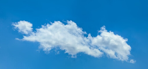 Obraz premium A relaxed clouds decomposing in the wind, spreads into a pancake shape. The lazy, hot structure of the steam. Bright blue sky with some cirrus clouds.
